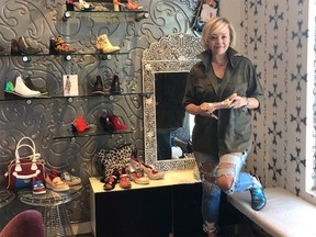 Dani Izzo, co-owner of Shoe Muse in Aspen Landing, stands amongst the shoes designed by her sister — Chanii B — as she begins a gradual reopening of her destination shop. While it’s now legal for her to reopen fully, Izzo says for the next two weeks she will see customers by appointment or chance with a full on opening on June 1.