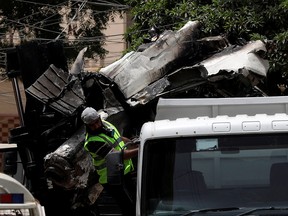 A worker reacts as a truck is loaded with the wreckage of the crashed Pakistan International Airlines' PK8303 plane, in Karachi, Pakistan, May 28, 2020.