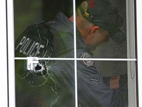 Police remove a bullet from a wall inside a home after an early morning shooting in Altadore on Wednesday, June 24, 2020.