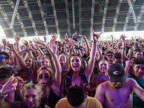 In this file photo taken on April 15, 2018 fans cheer as Petit Biscuit performs at the Coachella Music and Arts Festival in Indio, California,