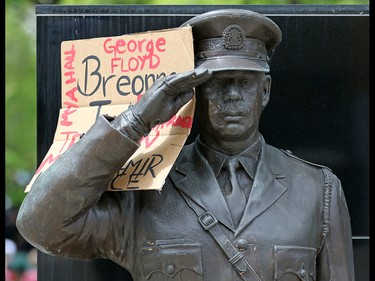 A protest sign is placed on a Calgary Police service statue while several thousand Calgarians participated in an anti-racist rally in downtown Calgary on Monday, June 1, 2020.  Gavin Young/Postmedia