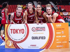Sami Hill, left, Bridget Carleton, Kia Nurse and Jamie Scott celebrate after Canada’s women’s basketball team qualified for the 2020 Tokyo Olympics on Saturday in Ostend, Belgium.