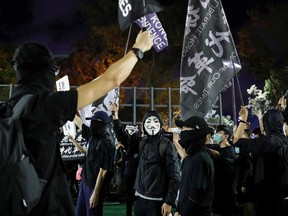 Protesters wearing protective face masks and coverings wave Hong Kong independence flags as they take part in a candlelight vigil to mark the 31st anniversary of the crackdown of pro-democracy protests at Beijing's Tiananmen Square in 1989, after police rejects a mass annual vigil on public health grounds, at Victoria Park, in Hong Kong, China June 4, 2020.