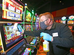 Jeremy Rodominski, food and beverage manager at Century Casino in Balzac, north of Calgary, cleans touchpoints on slot machines on Tuesday, June 9, 2020. They are preparing to open the doors when safely possible.