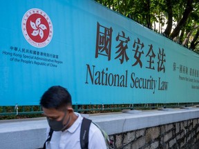A pedestrian walks past a government-sponsored advertisement promoting a new national security law in Hong Kong, China, on Tuesday, June 30, 2020.