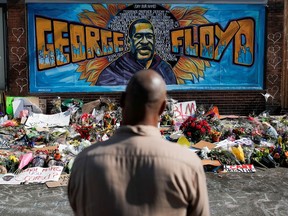 A local resident stands in front of a makeshift memorial honoring George Floyd, at the spot where he was taken into custody, in Minneapolis, Minnesota, U.S., June 1, 2020.