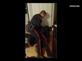 A still frame taken from a video Tara Yaschuk's son recorded of her being arrested by two Calgary Police Service officers. Yaschuk is alleging the officers used excessive force and assaulted her. She has filed a complaint under the Police Act and is requesting charges be laid against the officers.