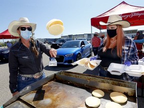 Calgary Stampede's Sandra Green flips some pancakes during the community pancake drive-thru presented by GMC at CrossIron Mills  on Saturday, July 4, 2020.