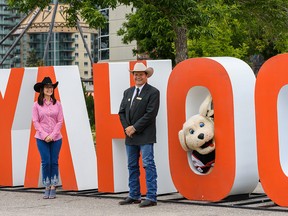 Karen Young, United Way of Calgary and area president and CEO, left, and Dana Peers, Stampede Board president and chairman, and Gordie the dog pose for a photo at Stampede Park on Tuesday, July 7, 2020.