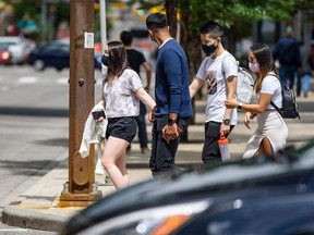 Pedestrians cross the street wearing masks in Downtown Calgary on Friday, July 17, 2020. Azin Ghaffari/Postmedia