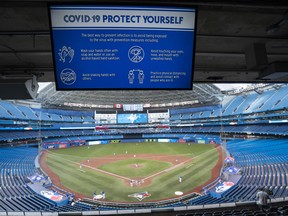 A COVID-19 warning sign is seen over the diamond at Rogers Centre on July 9, 2020 in Toronto, Canada.