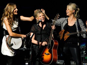 The Dixie Chicks' Emily Robison, left, and Martie Maguire, right, joke with Natalie Maines during their performance at the opening night of the Nokia Theatre L.A. Live in Los Angeles, Oct. 18, 2007.
