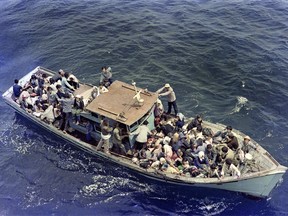 (FILES) A photo taken on July 8, 1979 shows Vietnamese refugees float in a boat in the Sea of China, waiting to be rescued by French hospital ship "Island of Light". In the late 1970s, a dramatic mobilization led France and other Western countries to host tens of thousands of boat people fleeing in dramatic terms the Vietnamese communist regimes but also Cambodian and Laotian.