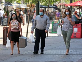 Calgarians wear masks as they walk along Stephen Avenue Mall in downtown Calgary on Wednesday, July 29, 2020. Calgary’s mandatory bylaw on transit and indoor public places begins on Saturday.