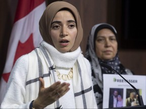 Safaa Eleshmawy (right), wife of Yasser Albaz, currently detained in Egypt, looks on as his daughter Amal Ahmed holds up a petition for his release during a news conference, Wednesday, December 11, 2019 in Ottawa.