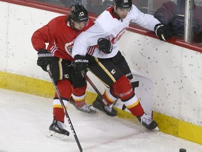 Johnny Gaudreau and Noah Hanifin collide along the boards during Calgary Flames training camp at the Saddledome in Calgary on July 14, 2020. Jim Wells/Postmedia