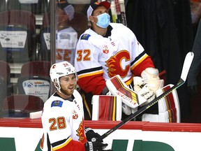 Elias Lindholm (28) skates in front of goalie Jon Gillies on bench during an NHL Calgary Flames intra-squad game at the Saddledome in Calgary on on Tuesday, July 21, 2020.