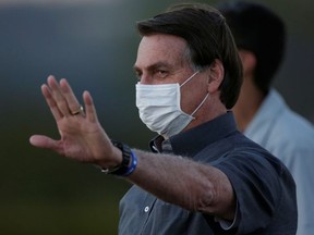 Brazil's President Jair Bolsonaro gestures during a ceremony to lower the Brazilian National flag down for the night, at the Alvorada Palace, amid the coronavirus disease (COVID-19) outbreak, in Brasilia, Brazil, July 20, 2020.