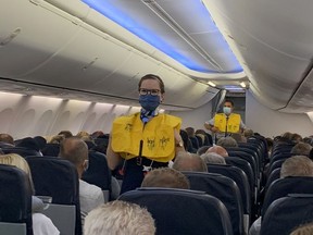 Flight attendants of TUI Fly wear face masks as they give instructions to German tourists on the first flight from Duesseldorf to Mallorca, two weeks before Spain starts reopening borders closed since mid-March to curb the coronavirus disease (COVID-19) pandemic, in Duesseldorf, Germany, June 15, 2020.
