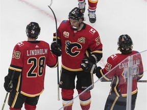 The Calgary Flames' Elias Lindholm, Matthew Tkachuk and Johnny Gaudreau celebrate a goal against the Edmonton Oilers during an NHL exhibition game at Rogers Place in Edmonton on Tuesday, July 28, 2020. /Jason Franson/THE CANADIAN PRESS ORG XMIT: EDM131