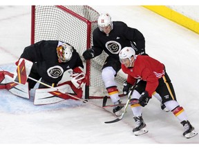 Calgary Flames Michael Stone and Derek Ryan come around the net on goaltender  David Rittich as they take part in the teamÕs first practice since the COVID-19 shutdown at the Scotiabank Saddledome in Calgary on Monday, July 13, 2020.  Gavin Young/Postmedia
