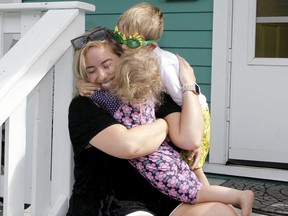 Melody Rodgers has her hands full as she is seen playing with her young children on the porch of their SW Calgary home on Thursday, July 16, 2020. Brendan Miller/Postmedia