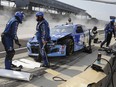 Crew members for the car driven by Ricky Stenhouse Jr. prepare to work on the car after a crash in the pit area during the Big Machine Hand Sanitizer 400 at Indianapolis Motor Speedway.