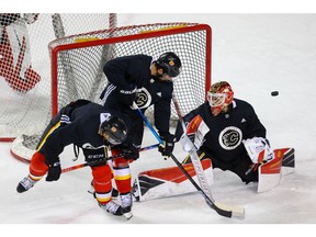 Mark Giordano battles Oliver Kylington in front of goalie Artyom Zagidulin during Calgary Flames training camp at the Saddledome in Calgary on Friday, July 17, 2020. Al Charest/Postmedia