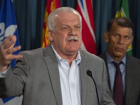 CLC President Hassan Yussuff (right) looks on as PSAC President Chris Aylward speaks during a news conference about pay equity in Ottawa, Wednesday, October 31, 2018.