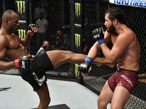 Kamaru Usman (left) kicks Jorge Masvidal during their welterweight championship fight at UFC 251 in Abu Dhabi's Yas Island.