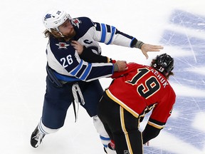 EDMONTON, ALBERTA - AUGUST 01: Blake Wheeler #26 of the Winnipeg Jets and Matthew Tkachuk #19 of the Calgary Flames fight in Game One of the Western Conference Qualification Round prior to the 2020 NHL Stanley Cup Playoffs at Rogers Place on August 01, 2020 in Edmonton, Alberta.