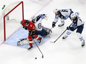 EDMONTON, ALBERTA - AUGUST 01: Sam Bennett #93 of the Calgary Flames goes for the puck as Connor Hellebuyck #37, Adam Lowry #17 and Mason Appleton #82 of the Winnipeg Jets defend during the first period in Game One of the Western Conference Qualification Round prior to the 2020 NHL Stanley Cup Playoffs at Rogers Place on August 01, 2020 in Edmonton, Alberta. (Photo by Jeff Vinnick/Getty Images)