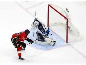 Flames forward Tobias Rieder steers a shot  on goal as Jets netminder Connor Hellebuyck defends during second-period action in Game 1 of the Western Conference Qualification Round prior to the 2020 NHL Stanley Cup Playoffs at Rogers Place late Saturday night in Edmonton. Photo by Jeff Vinnick/Getty Images.