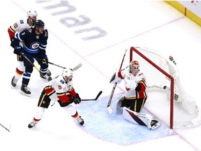 EDMONTON, ALBERTA - AUGUST 04: Andrew Copp #9 of the Winnipeg Jets celebrates his goal as Cam Talbot #39,Mikael ,Mark Giordano #5 and Derek Forbort #20 of the Calgary Flames react in the second period in Game Three of the Western Conference Qualification Round prior to the 2020 NHL Stanley Cup Playoffs at Rogers Place on August 04, 2020 in Edmonton, Alberta.