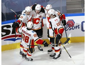 EDMONTON, ALBERTA - AUGUST 04: Matthew Tkachuk #19 of the Calgary Flames is congratulated by teammates Andrew Mangiapane #88,Mikael Backlund #11,Oliver Kylington #58 and Derek Forbort #20 after Tkachuk scored a goal in the second period against the Winnipeg Jets in Game Three of the Western Conference Qualification Round prior to the 2020 NHL Stanley Cup Playoffs at Rogers Place on August 04, 2020 in Edmonton, Alberta.