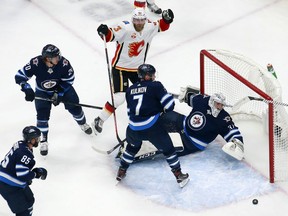 Sam Bennett of the Calgary Flames scores a goal past Connor Hellebuyck of the Winnipeg Jets during the first period in Game 4 of the Western Conference Qualification Round prior to the 2020 NHL Stanley Cup Playoffs at Rogers Place on August 6, 2020, in Edmonton, Alberta.