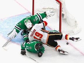 Dallas Stars goaltender Anton Khudobin and teammate Andrew Cogliano defend against Matthew Tkachuk of the Calgary Flames during the second period in Game 1 of the Western Conference first-round series during the 2020 NHL Stanley Cup Playoffs  on Tuesday in Edmonton.