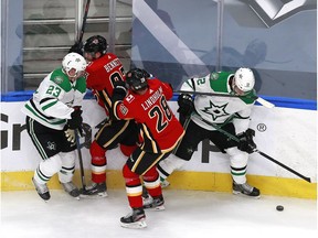 Radek Faksa #12 and Esa Lindell #23 of the Dallas Stars battle for the puck with Elias Lindholm #28 and Sam Bennett #93 of the Calgary Flames during the first period in Game Two of the Western Conference First Round during the 2020 NHL Stanley Cup Playoffs at Rogers Place on August 14, 2020 in Edmonton, Alberta, Canada. (Photo by Jeff Vinnick/Getty Images)