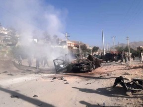 People inspect a police vehicle which was hit by magnetic bomb in Kabul, Afghanistan July 28, 2020.