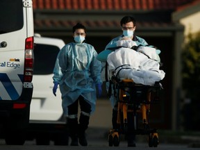 A patient is removed from an aged care facility experiencing an outbreak of the coronavirus disease in Melbourne, Australia, July 31, 2020.