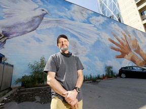 Doug Driediger with the mural he painted titled Giving Wings to the Dream at the old CUPS building on 7th Avenue on Tuesday, Aug. 11, 2020. The beloved mural is slated to be painted over after the city put out a call for artists of colour to paint murals for Black Lives Matter.