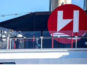 People clean the MS Roald Amundsen ship, operated by Norway's Hurtigruten line, after its crew members were diagnosed with the coronavirus disease, at a port in Tromso, Norway, Saturday, Aug. 2, 2020.