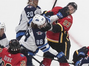 Winnipeg Jets' Nathan Beaulieu (88) and Calgary Flames' Sam Bennett (93) rough it up during first period NHL qualifying round game action in Edmonton, on Monday August 3, 2020.
