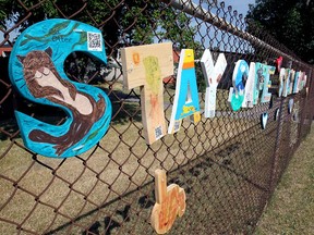 Sign on the fence outside St. Benedict School in the SW. Wednesday, August 19, 2020.