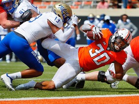 Oklahoma State running back Chuba Hubbard pushes past a tackle to score a touchdown against Tulsa’s Lamar Mullins at Boone Pickens Stadium in Stillwater, Okla., on Sept. 19, 2020.  OSU won 16-7. Brian Bahr/Getty Images