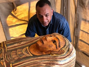 Mostafa al-Waziri, secretary-general of Egypt's Supreme Council of Antiquities looks at one of the 2,500-year-old coffins discovered in a burial shaft in the desert near Saqqara necropolis in Egypt, in this undated image released on Sept. 19, 2020 by the Egyptian Ministry of Antiquities.