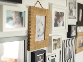 white wall with photos of the family in various photo frames