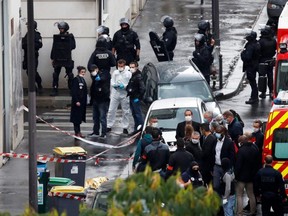 Police officers investigate the scene of an incident near the former offices of French magazine Charlie Hebdo, in Paris, France September 25, 2020. REUTERS/Gonzalo Fuentes ORG XMIT: GDN