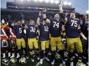 CP-Web.  FILE - In this Nov. 2, 2019, file photo, members of the Notre Dame football team sing after an NCAA college football game against Virginia Tech in South Bend, Ind. The Atlantic Coast Conference and Notre Dame are considering whether the Fighting Irish will give up their treasured football independence for the 2020 season play as a member of the league.