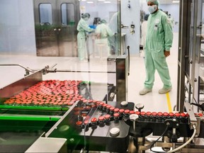 A laboratory technician supervises capped vials during filling and packaging tests for the large-scale production and supply of the University of Oxford's COVID-19 vaccine candidate, AZD1222, conducted on a high-performance aseptic vial filling line on Friday, Sept. 11, 2020, at the Italian biologics manufacturing facility of multinational corporation Catalent in Anagni, southeast of Rome.